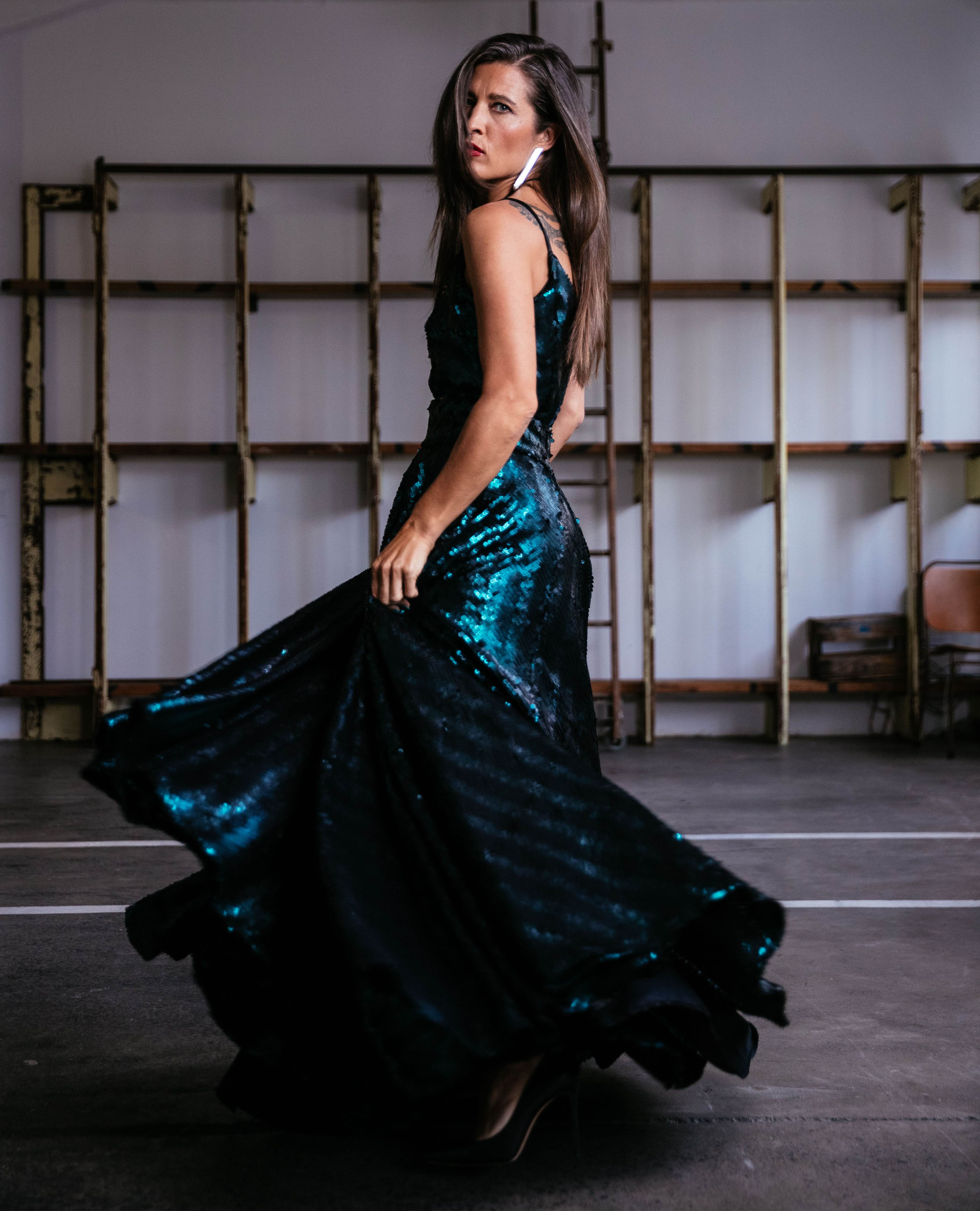 Chelsea Winstanley on producing mana enhancing films and redefining success 5 Chelsea Winstanley looks back at the camera while twirling in a deep green steel sequin slip dress by Kiri Nathan