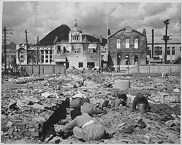 Korean women and children search the rubble of Seoul for anything that can be used or burned as fuel in the Korean War. 